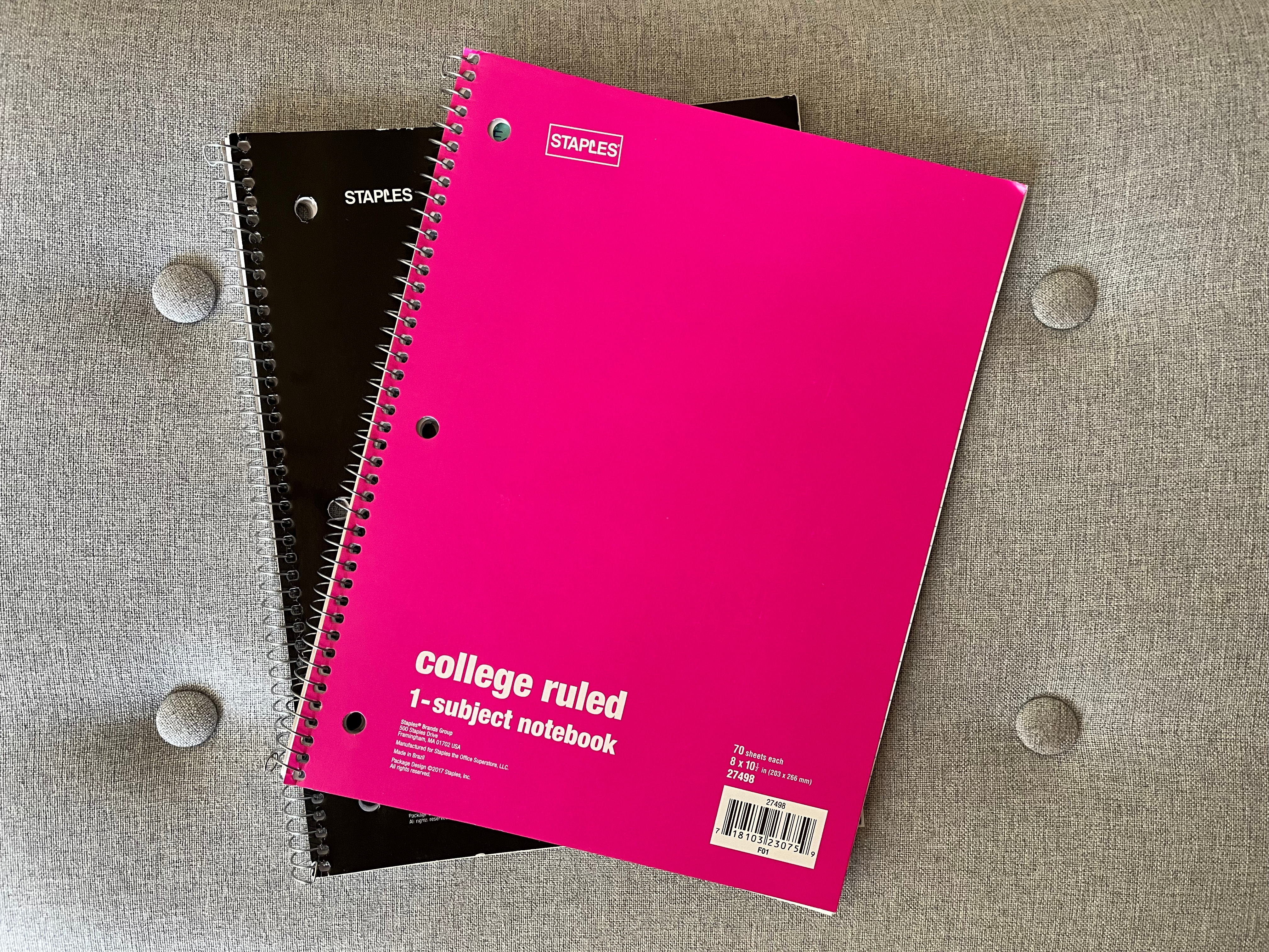 A photo of 2 spiral notebooks, one with a hot pink cover and one with a black cover.