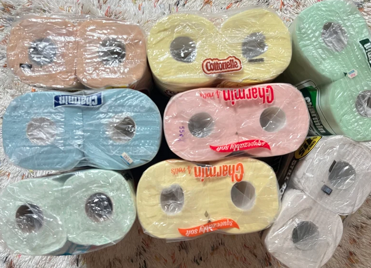 Packages of vintage toilet paper in tan, light blue, yellow, pink and light green.