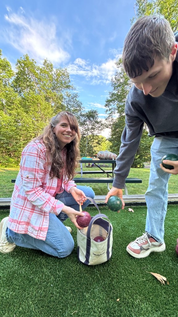 Photo of me and my nephew loading bocce balls into a canvas tote bag.